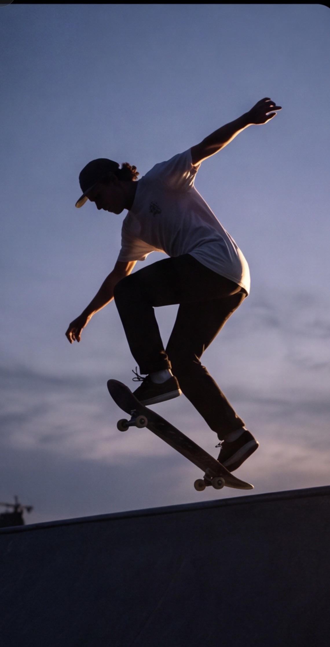 Skateboarder i silhuet over en rampe